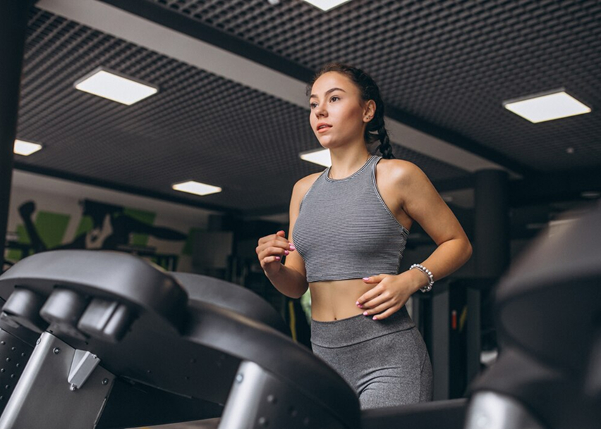 Девушка на беговых дрожках в спортзале